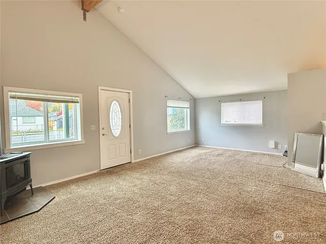 a kitchen with stainless steel appliances granite countertop a refrigerator a stove and a sink with large window