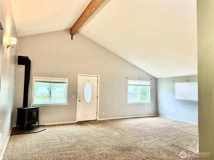 a kitchen with stainless steel appliances granite countertop a refrigerator a stove and a sink with large window