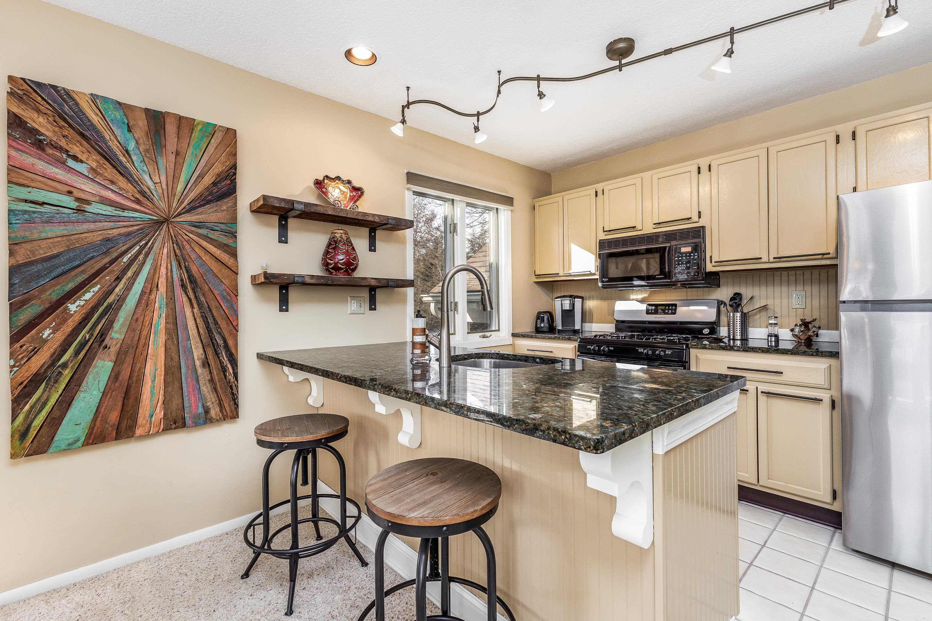 4 Timberline Drive Galena, IL 61036 - Photo 31 of 32 a kitchen with kitchen island granite countertop a sink a counter top space appliances and cabinets