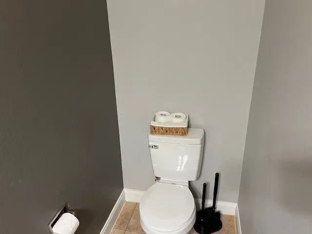 a white toilet sitting next to a white wall