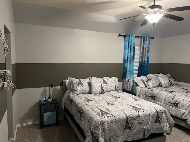 a bed room with two twin beds and a ceiling fan