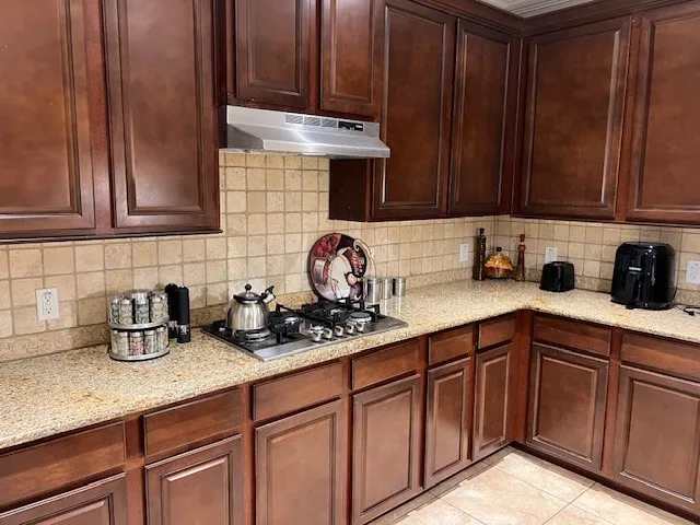 a kitchen with stainless steel appliances granite countertop wooden cabinets and a counter top space