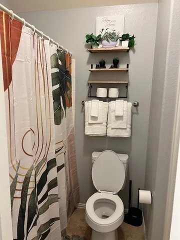 a bathroom with a toilet and a mirror