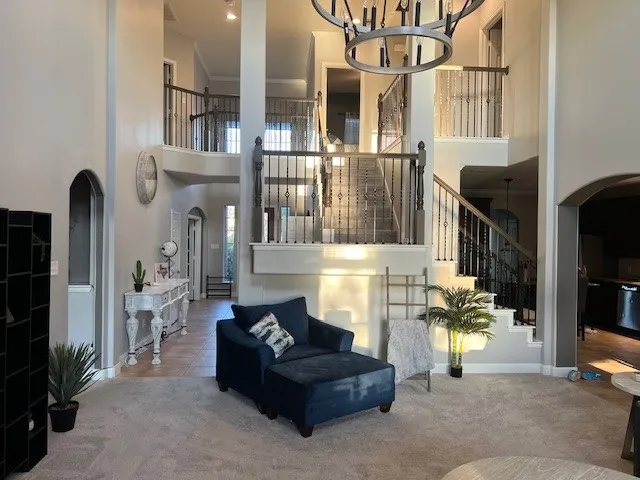 a living room with furniture a chandelier and a flat screen tv