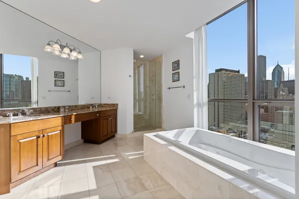 a spacious bathroom with a tub sink and mirror