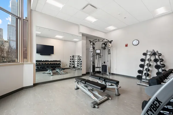 a room with gym equipment and a flat screen tv
