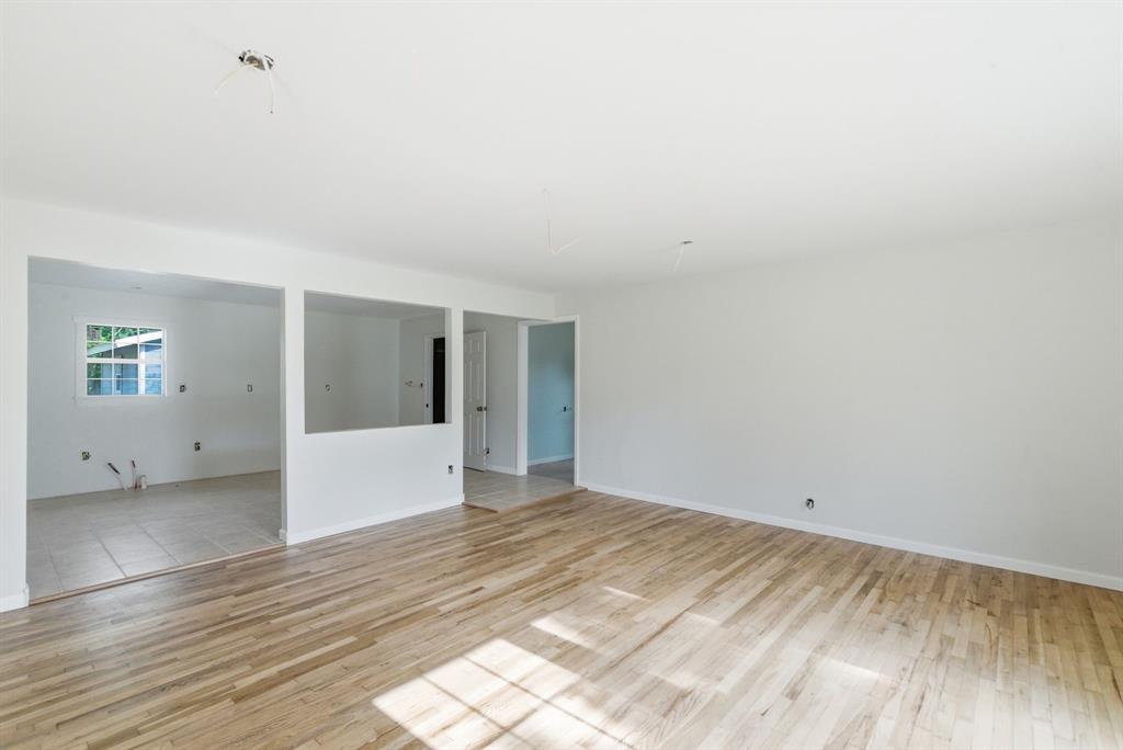 203 North Kickapoo Street Lipan, TX 76462 - Photo 9 of 28 a view of an empty room with wooden floor and a window