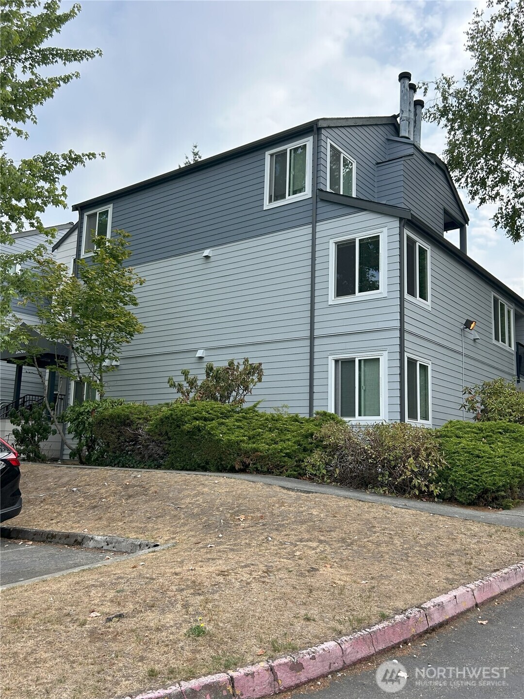20318 Bothell Everett Highway, Unit A303 Bothell, WA 98012 - Photo 11 of 12 a front view of a house with a yard and garage