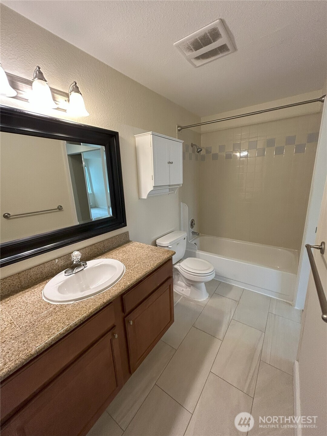 20318 Bothell Everett Highway, Unit A303 Bothell, WA 98012 - Photo 7 of 12 a bathroom with a granite countertop sink a toilet a mirror and shower