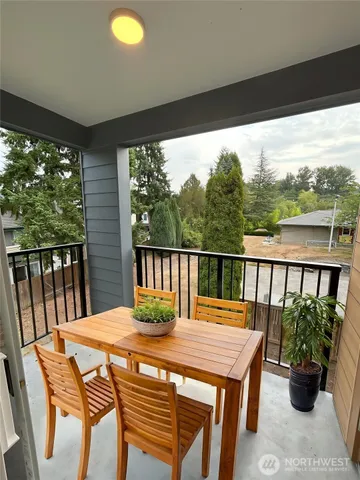 a view of a balcony with chairs and wooden floor