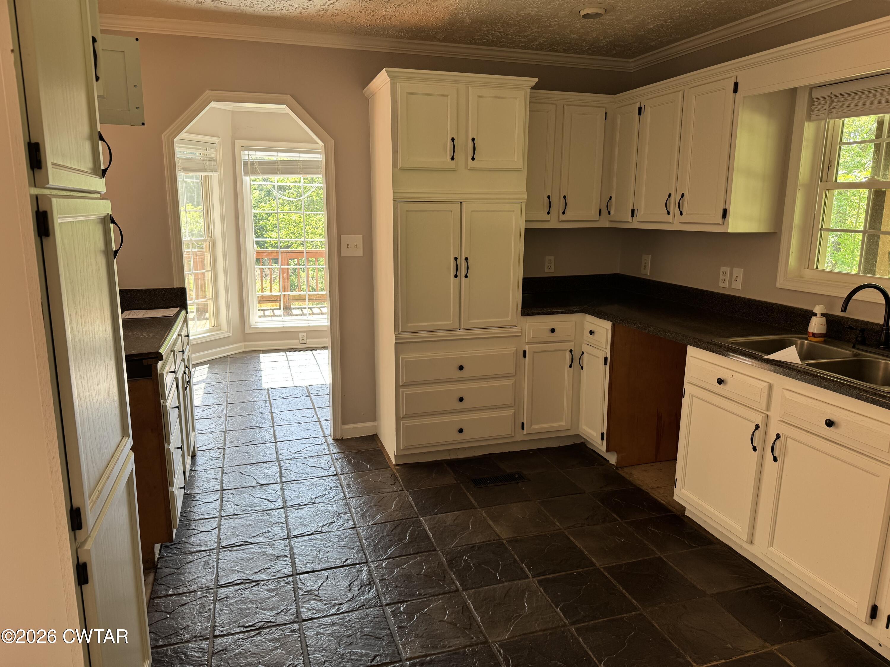 597 Broadway Road North Lexington, TN 38351 - Photo 4 of 15 a kitchen with granite countertop a stove a sink a refrigerator a window and cabinets