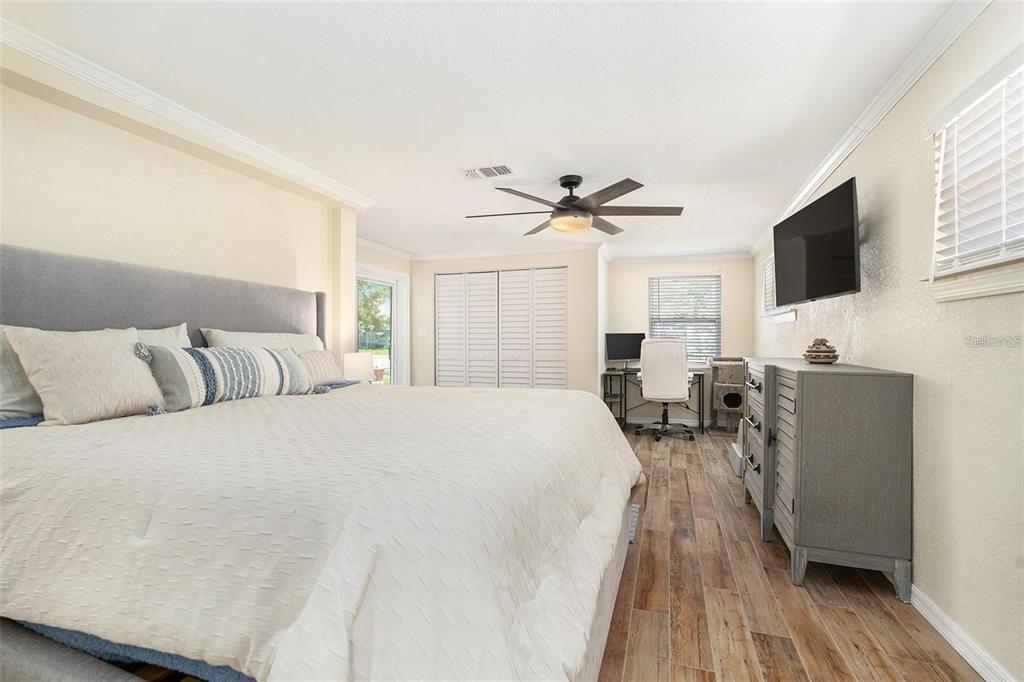 13401 Neptune Drive Hudson, FL 34667 - Photo 12 of 21 a spacious bedroom with a bed a couch and a flat screen tv