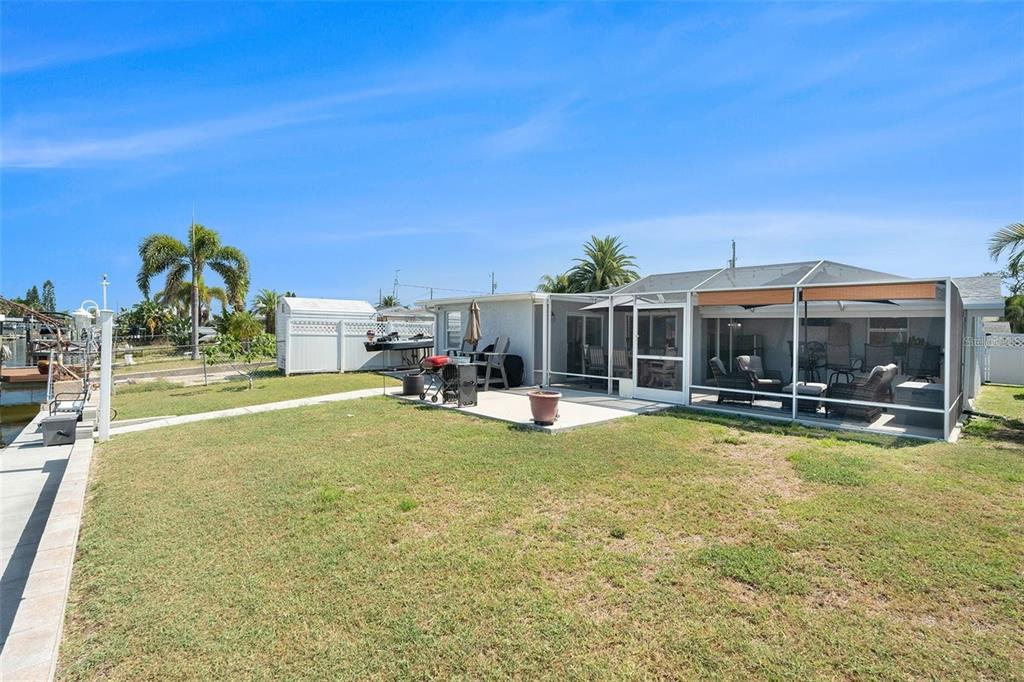 13401 Neptune Drive Hudson, FL 34667 - Photo 19 of 21 a view of swimming pool with lawn chairs and large tree