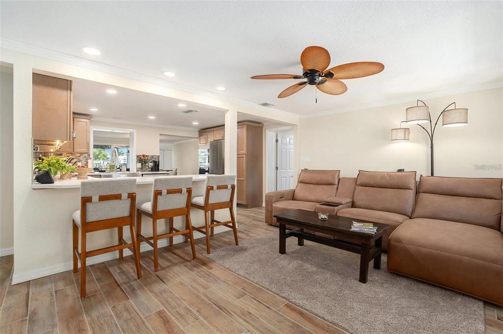 13401 Neptune Drive Hudson, FL 34667 - Photo 4 of 21 a living room with furniture a dining table and wooden floor