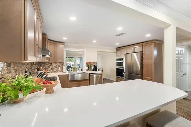 a kitchen with stainless steel appliances a refrigerator sink and stove