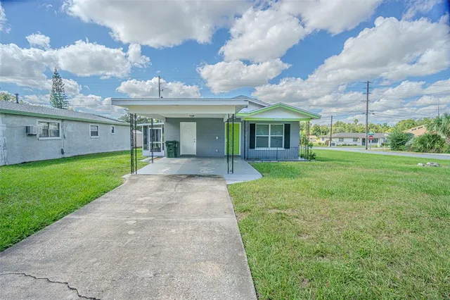 a view of a big house with a big yard and potted plants