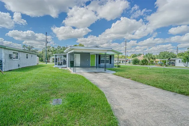 a view of a house with a big yard and a large tree