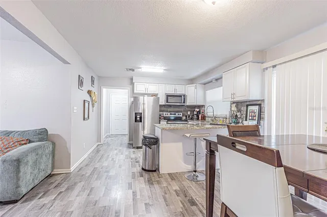 a kitchen with stainless steel appliances granite countertop a refrigerator a stove top oven a sink and dishwasher