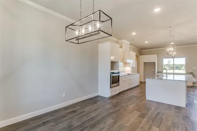 a view of a kitchen with a sink and dishwasher a refrigerator with wooden floor