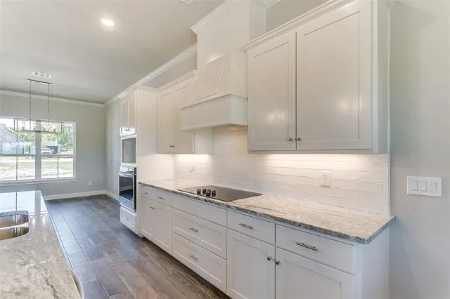 a kitchen with granite countertop white cabinets and white appliances