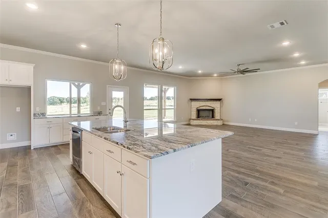 a kitchen with granite countertop a stove oven and a wooden floor