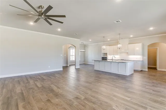 a view of kitchen with kitchen island white cabinets and stainless steel appliances