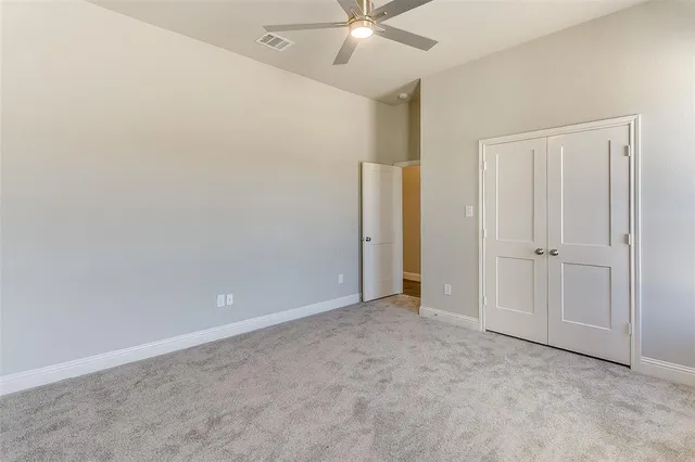 an empty room with closet and fan