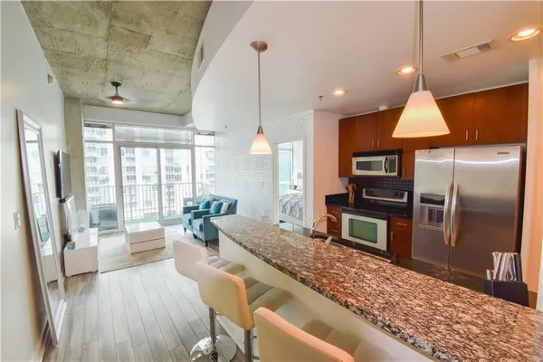 a large kitchen with sink a refrigerator and wooden floor