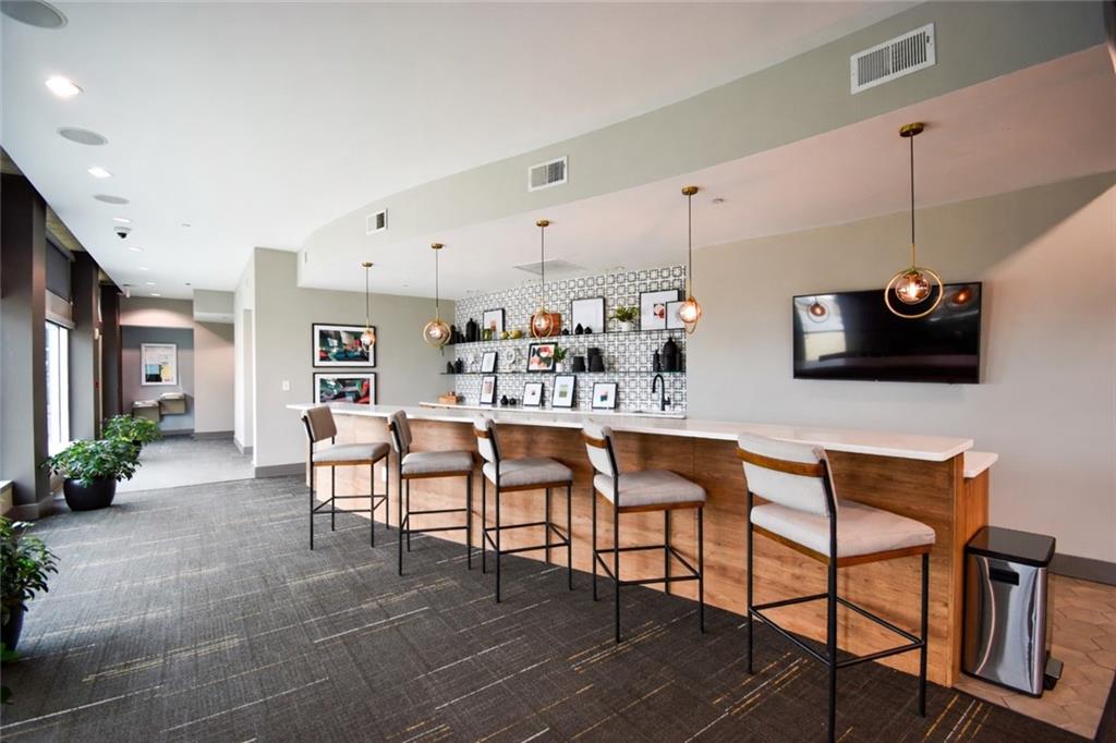 250 Pharr Road Northeast, Unit 1103 Atlanta, GA 30305 - Photo 12 of 16 a outdoor kitchen with stainless steel appliances kitchen island granite countertop a table and chairs in it