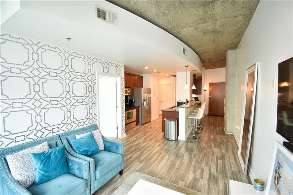 250 Pharr Road Northeast, Unit 1103 Atlanta, GA 30305 - Photo 4 of 16 a living room with furniture and a wooden floor