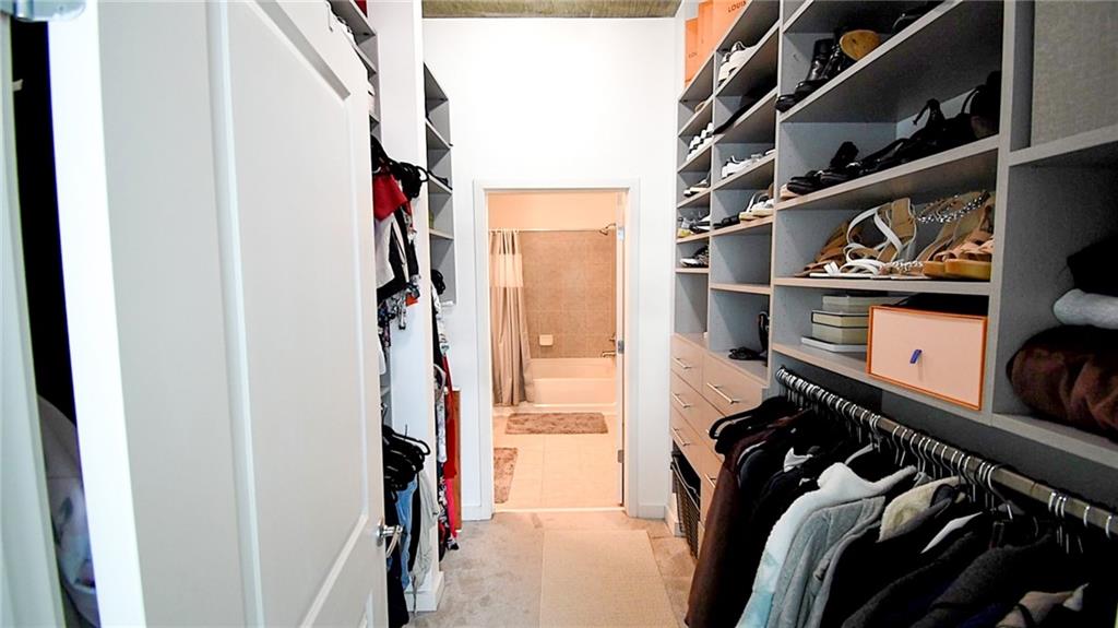 250 Pharr Road Northeast, Unit 1103 Atlanta, GA 30305 - Photo 8 of 16 a view of walk in closet with clothes and shoes