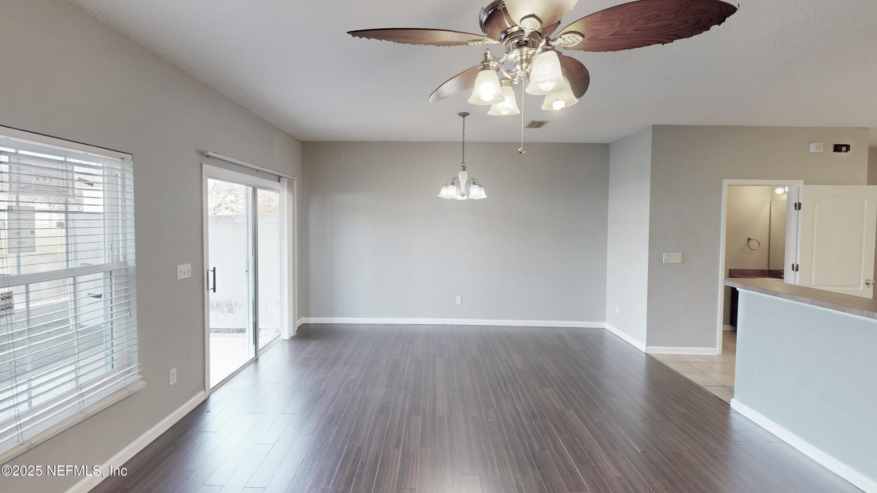 1445 Biscayne Bay Drive Jacksonville, FL 32218 - Photo 2 of 10 a view of an empty room with wooden floor and a window