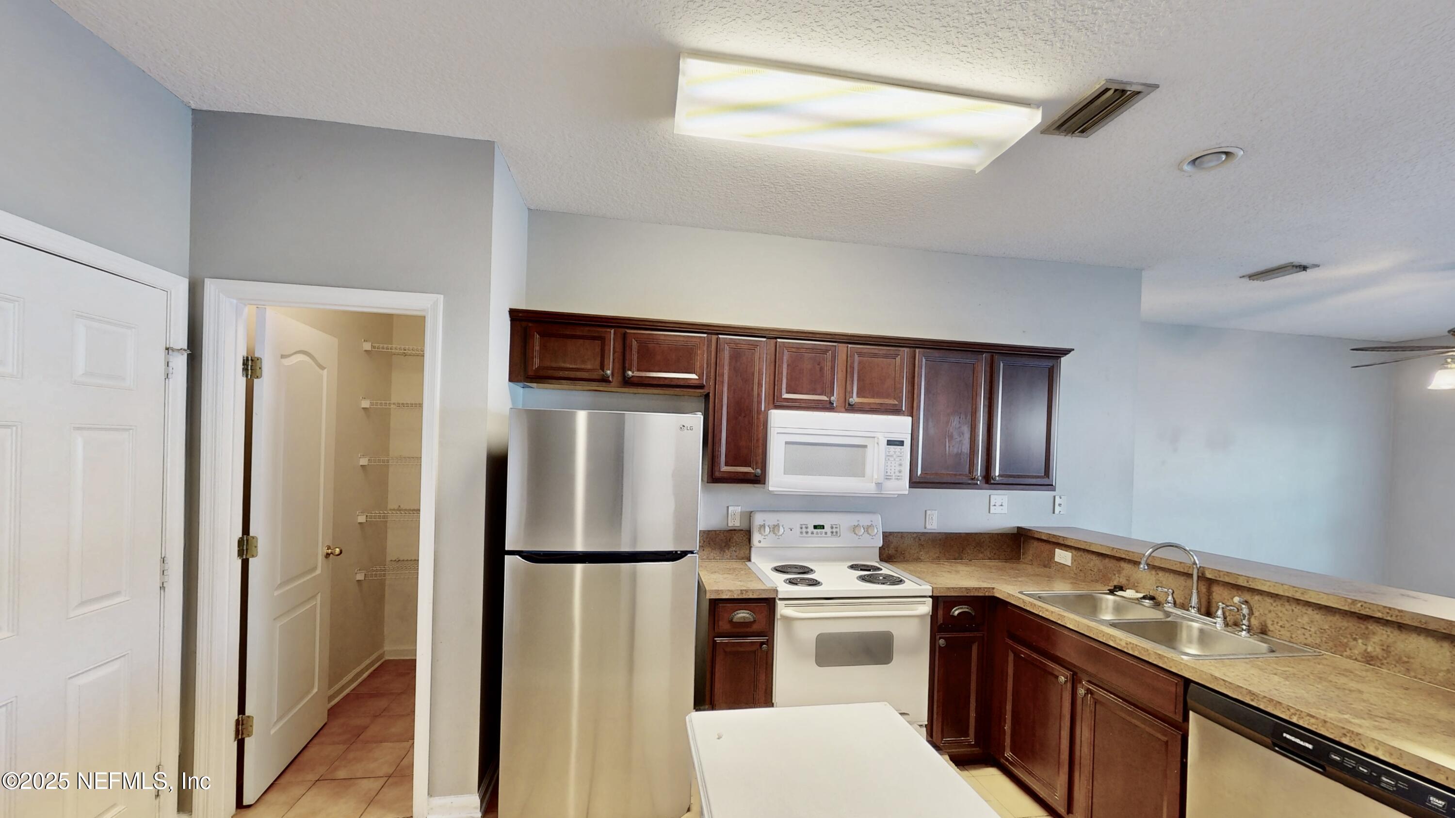 1445 Biscayne Bay Drive Jacksonville, FL 32218 - Photo 3 of 10 a kitchen with stainless steel appliances granite countertop a refrigerator stove and sink