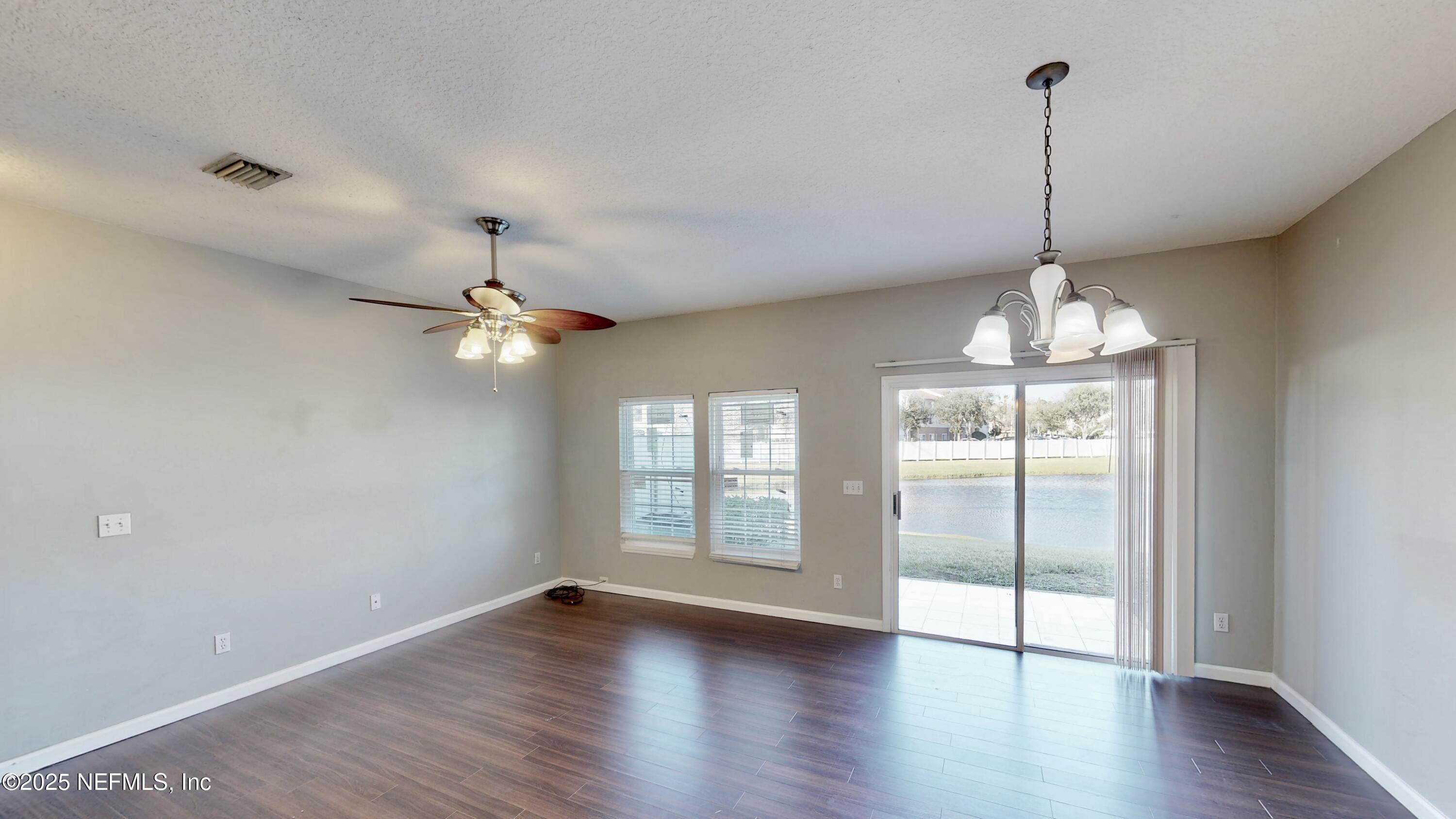 1445 Biscayne Bay Drive Jacksonville, FL 32218 - Photo 4 of 10 a view of a room with wooden floor chandelier and windows