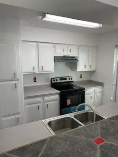a kitchen with a stove and a wooden floor
