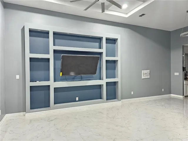 a view of an empty room with a fireplace and window