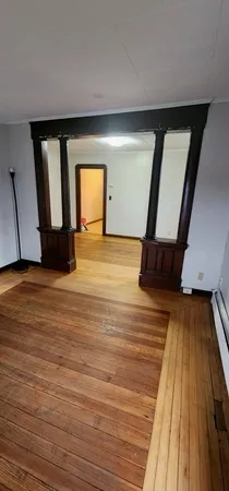 a view of empty room with wooden floor