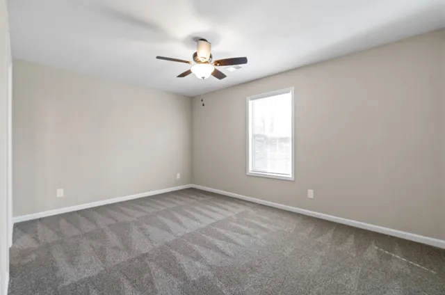 a view of an empty room and a ceiling fan