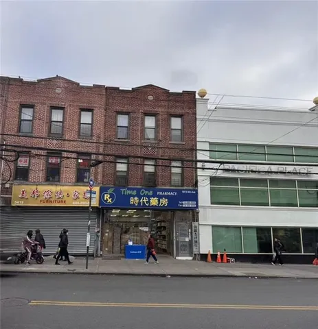 a view of a large building and a couple of cars parked in front of it