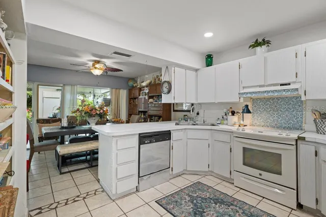 a kitchen with white cabinets and white appliances