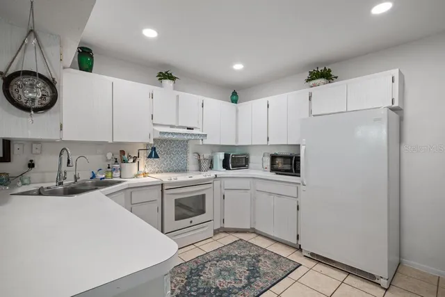 a kitchen with granite countertop a sink cabinets stainless steel appliances and a counter top space
