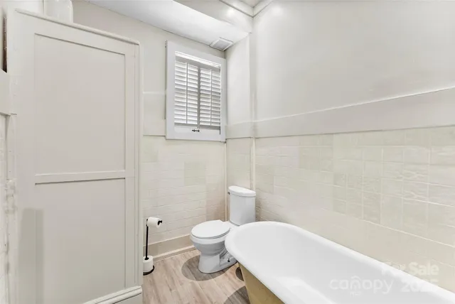 a white toilet sitting next to a bath tub