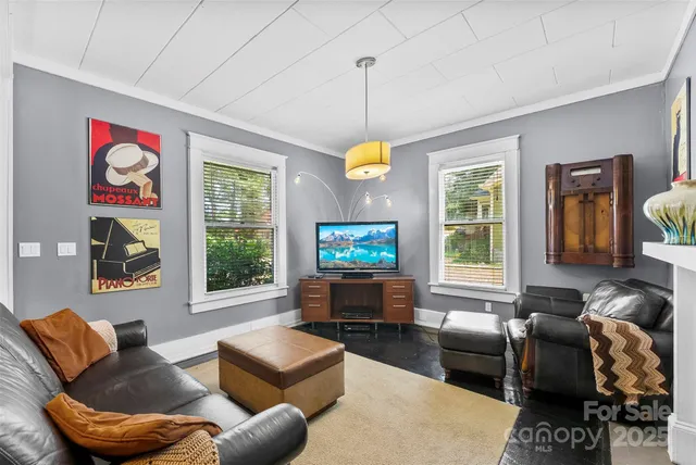 a living room with furniture a flat screen tv and a window