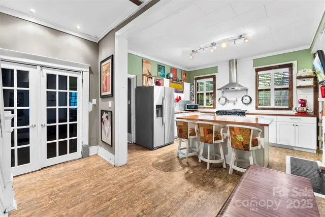 a kitchen with stainless steel appliances kitchen island granite countertop a refrigerator and a sink