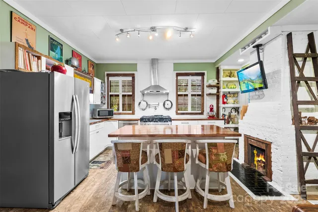 a kitchen with stainless steel appliances granite countertop a refrigerator and a stove