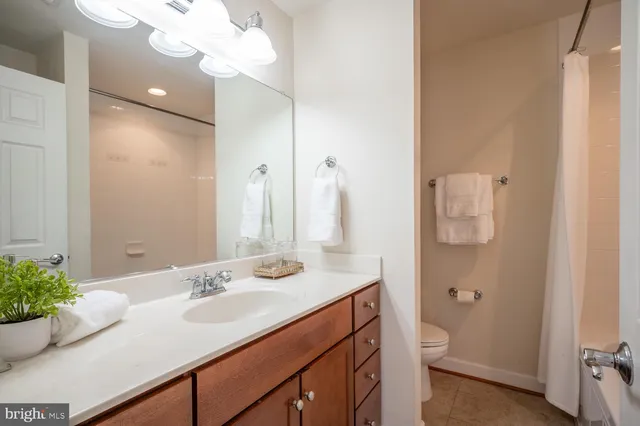 a bathroom with a sink vanity granite and toilet