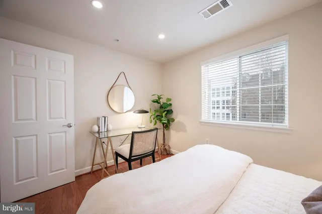 a bedroom with a bed a mirror and a window