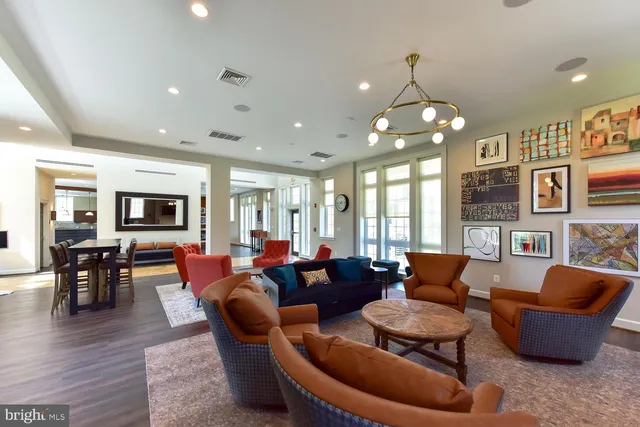 a living room with furniture kitchen view and a large window
