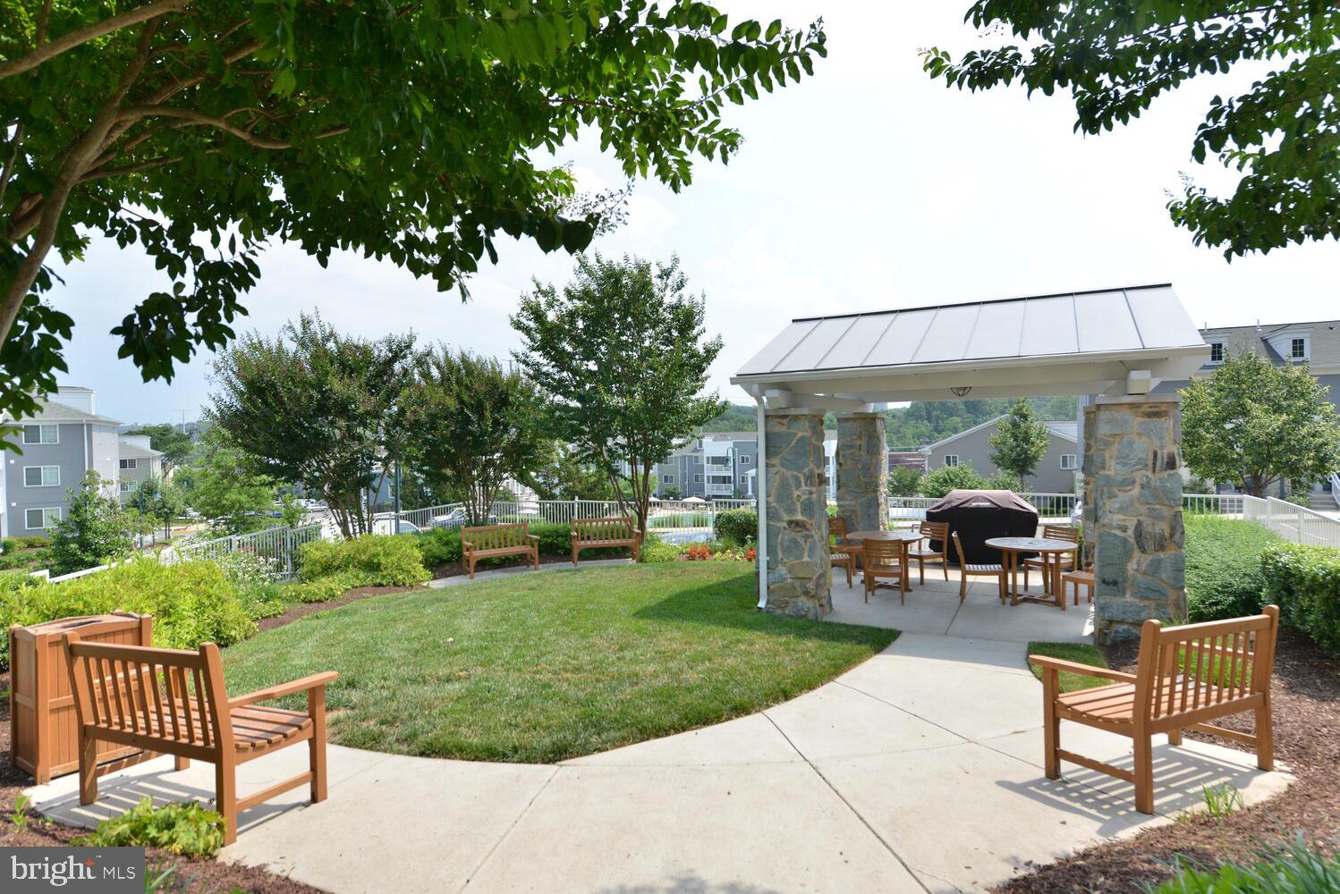 4113 South Four Mile Run Drive, Unit 404 Arlington, VA 22204 - Photo 34 of 39 a view of a patio with a table chairs and a yard