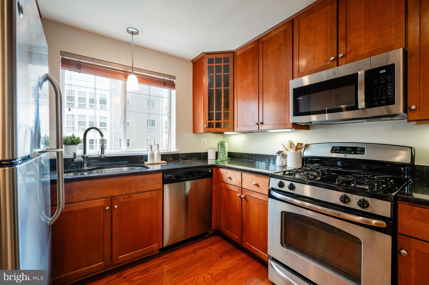 4113 South Four Mile Run Drive, Unit 404 Arlington, VA 22204 - Photo 7 of 39 a kitchen with stainless steel appliances a stove microwave and sink